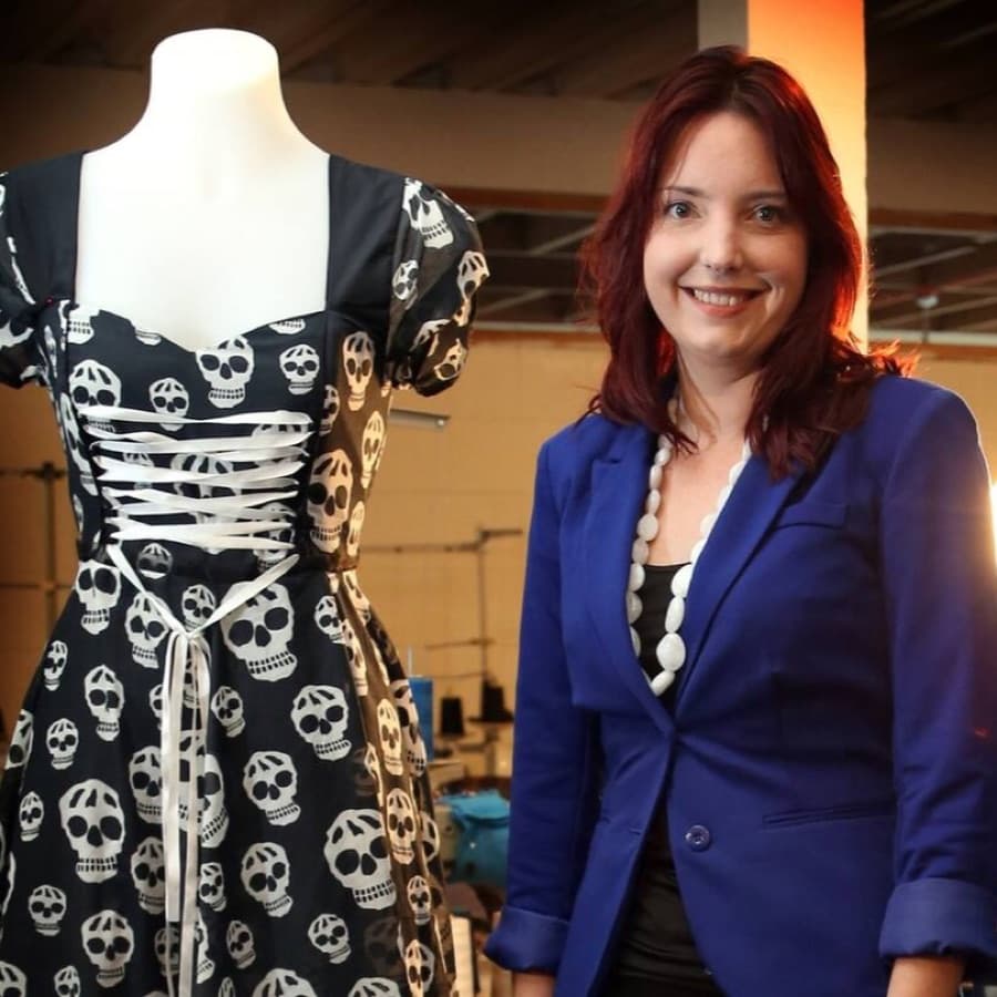 Sara Fredrickson beside a dressmaker’s mannequin wearing a patterned dress
