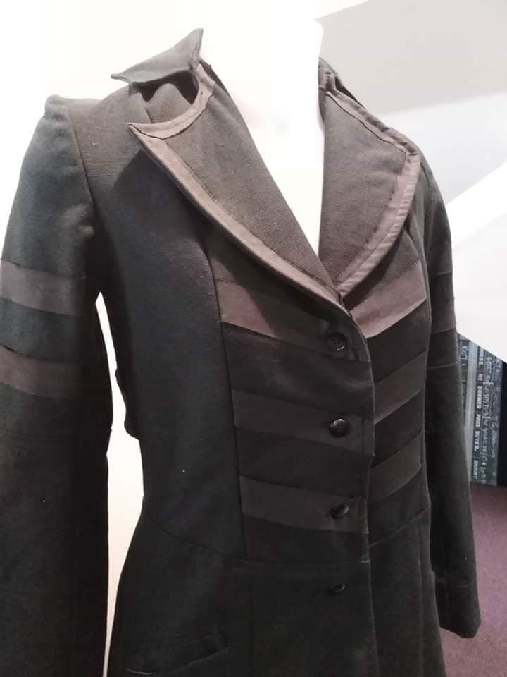A tailored wool coat hanging ready for alteration